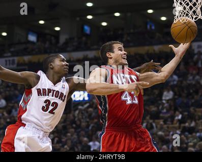 New Jersey Nets forward Kris Humphries (C) passes the ball as Chicago Bulls  center Omer Asik (L) and forward Brian Scalabrine defend during the second  quarter at the United Center on January
