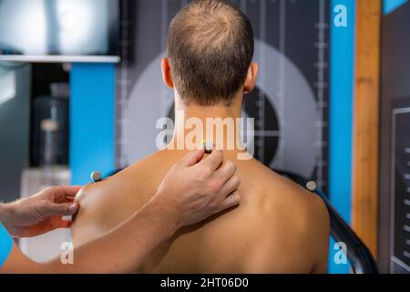 Placing markers on man's back for 3D gait analysis Stock Photo