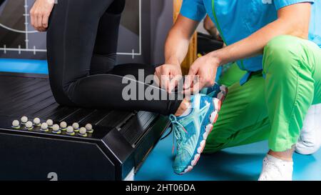 Placing markers for 3D gait analysis in a sports laboratory Stock Photo