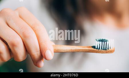 Woman brushing teeth with charcoal Stock Photo
