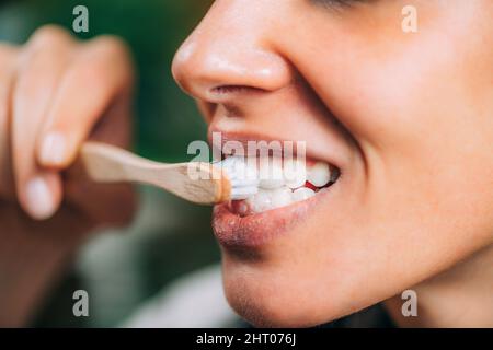 Woman brushing teeth with charcoal toothpaste Stock Photo