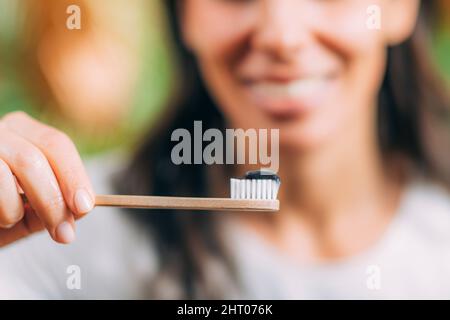 Toothpaste with black charcoal on wooden toothbrush Stock Photo