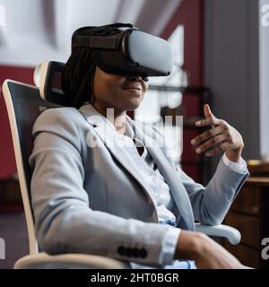 Businesswoman use virtual reality goggles communicate online during vr meeting conference at office Stock Photo