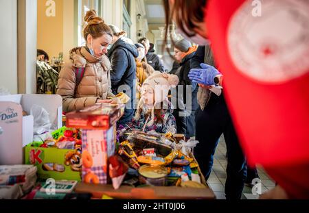 Przemysl, Poland. 26th Feb, 2022. Helpers distribute food and sweets to refugees at the train station in Przemysl. Numerous Ukrainians are leaving the country after Russia's military actions on Ukrainian territory. (To dpa Poland helps refugees) Credit: Michael Kappeler/dpa/Alamy Live News Stock Photo