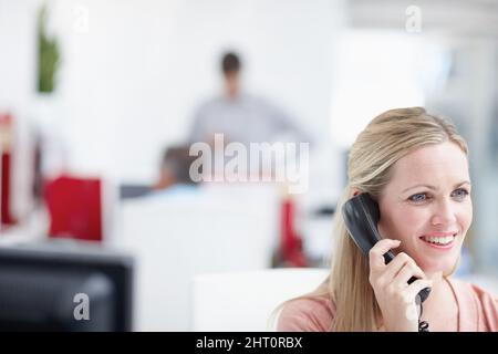 Pretty professional surrounded by copyspace. A female professional having a conversation on the phone alongside an impressive amount of copyspace. Stock Photo