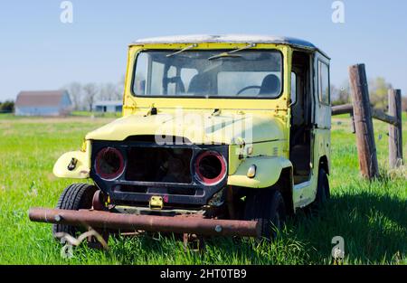 Beautiful shot of a yellow vintage Jeep in a field Stock Photo