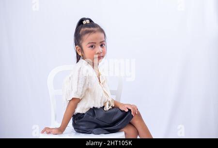 Adorable Southeast Asian school girl from Malaysia posing wearing makeup and stylish clothing Stock Photo