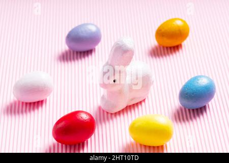 Easter eggs and white bunny. Easter decorations on a pink pastel background. Top view Stock Photo