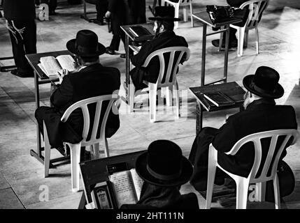 Grayscale of men sitting on a chair from behind Stock Photo