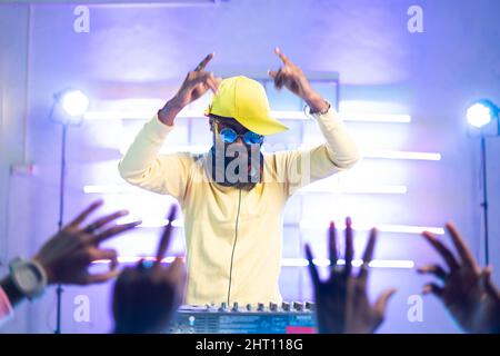 audience waving hand for dj player music at music concert - concept of nightclub, entertainment and hip hop rapper Stock Photo