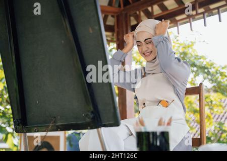 muslim female thinking while working in her project at studio Stock Photo