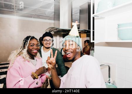 Portrait of cheerful multiracial male and female students in kitchen at college dorm Stock Photo