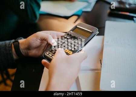 Hands of young male student using calculator at university Stock Photo