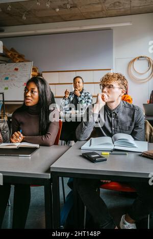 University students sitting at desk in classroom Stock Photo