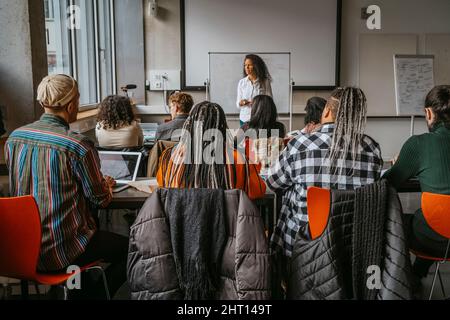 Female professor teaching university students in classroom Stock Photo