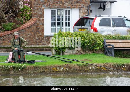 BUDE, CORNWALL, UK - AUGUST 15 : Man fishing on the canal at Bude in Cornwall on August 15, 2013. One unidentified man Stock Photo