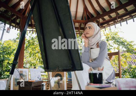 muslim female thinking while working in her project at studio Stock Photo