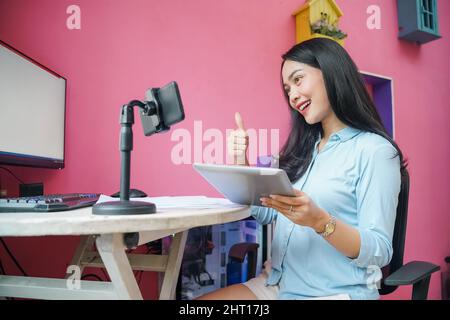 Freelancer woman working using phone with thumbs up hand gesture Stock Photo