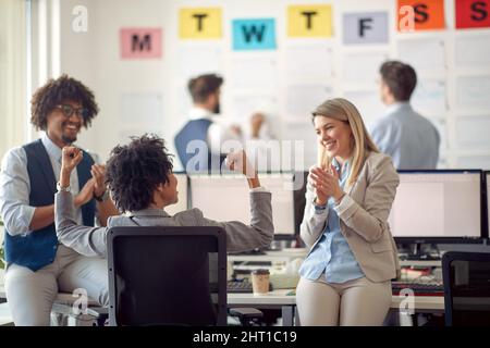 A group of cheerful employees is having a friendly talk in a pleasant atmosphere in the office. Employees, job, office Stock Photo