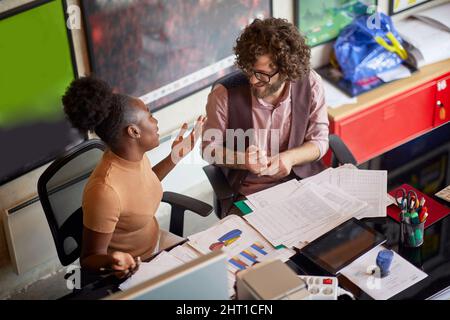 Young motivated employees doing paperwork together in the office Stock Photo