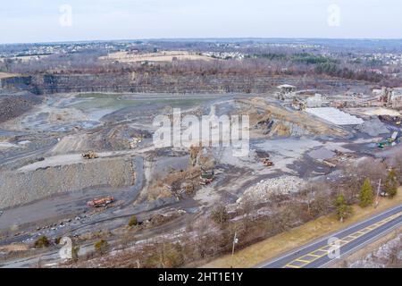 Aerial view of the open pit loader loading gravel into stone jaw crusher in open-pit quarry development Stock Photo