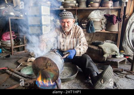 Manisa,Turkey - 04-21-2016:Old craftsman in the tinsmith workshop Stock Photo