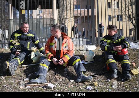 Kyiv, Ukraine. 26th Feb, 2022. Firefighters rest after battling a fire at the site of a rocket strike on an apartment building in Kyiv, Ukraine on Feb. 26, 2022. The strike happened in the early hours of the morning on Feb. 26, 2022 with an unknown number of dead and injured. Russia continued its offensive into Ukraine during the night with rocket attacks and deployment of ground troops in multiple areas. (Photo by Justin Yau/Sipa USA) Credit: Sipa USA/Alamy Live News Stock Photo