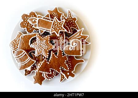 Christmas homemade gingerbread on a plate, handmade, various molds, top view on a white wooden table. Stock Photo