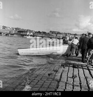 The search for the missing pleasure boat Darlwyne which sunk on the 31st July 1966. The tragic sinking of the Darlwyne led to the loss of 31 lives and the wreck of the boat was never found. The bodies of only 12 of the 31 people on board were ever recovered. Pictured, the dinghy of the missing Darlwyne being brought ashore. 1st August 1966. Stock Photo