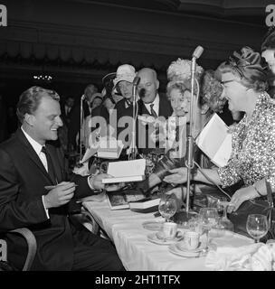 Billy Graham signs copies of his book 'World Aflame' at Foyles Literacy Luncheon held in the Dorchester Ballroom. The event was held in his honour. 30th June 1966. Stock Photo