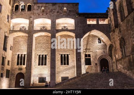 Barcelona, Oct 2021: Plaça del Rei medieval square in Barcelona city center at night, stone buildings lightened, famous stairs where tourists rest, Ca Stock Photo