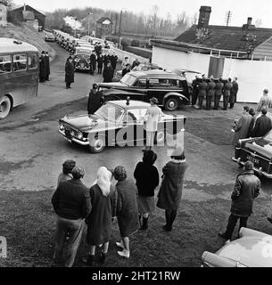 A full scale rehearsal of Sir Winston Churchill's funeral is carried out in Oxfordshire. The scene at Hanborough Station, villagers watch the pallbearers from the Irish Guards place the coffin in the motor hearse. Lined up in the background are ten Roll Royce cars that will carry the mourners the two mile Journey to Bladon Churchyard for the interment. 28th January 1965. Stock Photo