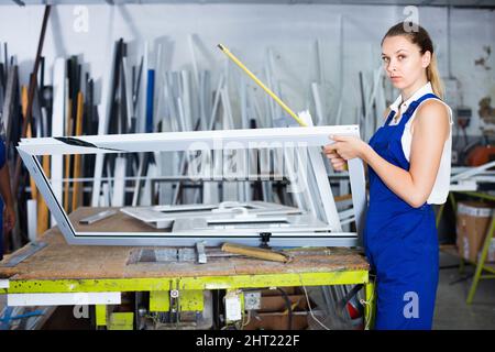 woman using measuring tape in her work in production of pvc windows Stock Photo