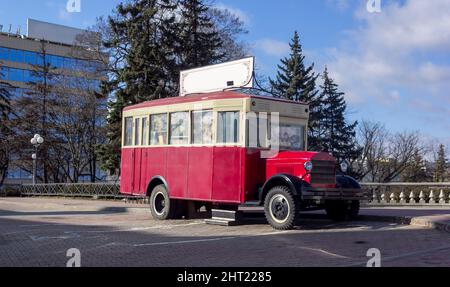 Old retro red bus in Europe. Rusty rough metal surface texture. Antique vintage soviet automobile bus. Side view. Stock Photo