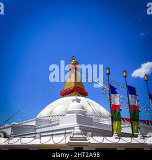 Low angle shot of Boudha Stupa, Boudhanath against a blue sky on a sunny day, Kathmandu, Nepal Stock Photo