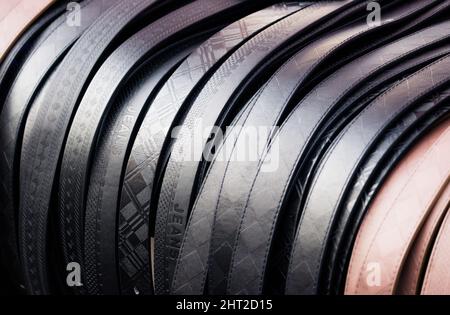 Leather belts for sale at a local clothing market stall Stock Photo