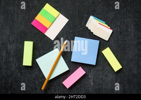 Blank paper self-adhesive multicolored sticks on a dark background Stock Photo