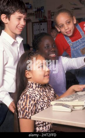 multicultural group of junior school children on computer (c. 1998) Stock Photo
