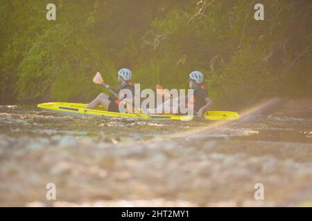 Selective focus on the sunlight while two kayakers are kayaking together Stock Photo