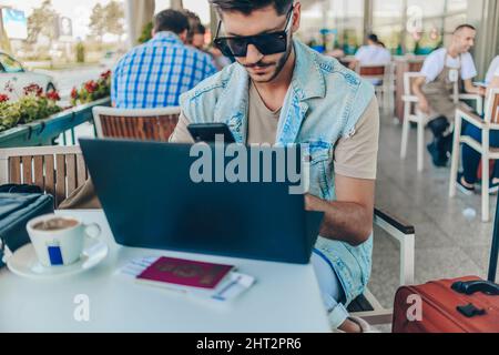 Young man working on laptop while waiting to take off Stock Photo
