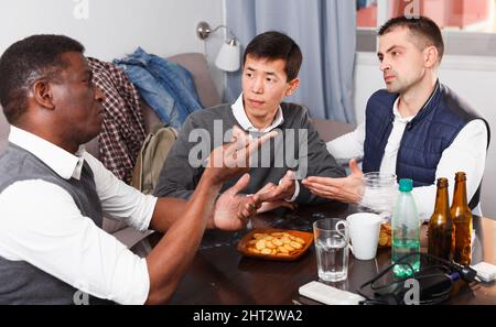 Three men are drinking beer and arguing in time rest together Stock Photo