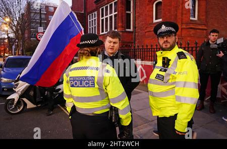 Police speak to a person taking part in a demonstration outside the Russian Embassy in Kensington Palace Gardens, west London, to denounce the Russian invasion of Ukraine. Picture date: Saturday February 26, 2022. Stock Photo
