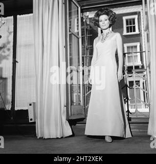 Irina Demick, french actress, in the UK for premiere of new film, Those Magnificent Men in their Flying Machines, in which she plays the multiple characters of as Brigitte, Ingrid, Marlene, Francoise, Yvette and Betty. Pictured wearing her gown for this evening, in her suite at Claridge's Hotel, London, Wednesday 2nd June 1965. Stock Photo