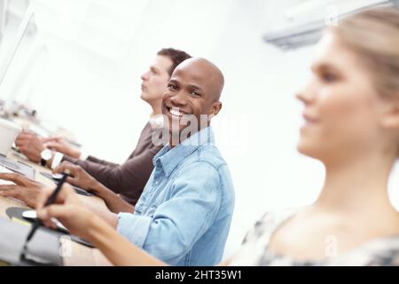 I love my job. Portrait of three coworkers working hard on the computers in the office. Stock Photo