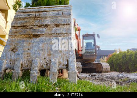 Crawler excavator digging on demolition in construction site concept idea. Low, macro, front view of parked excavator. Empty copy space, blank area on Stock Photo