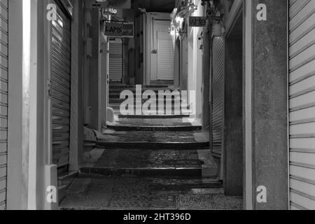 Santorini,  Greece - May 9, 2021 : An  empty alley with closed shops in the center of Fira Santorini Stock Photo