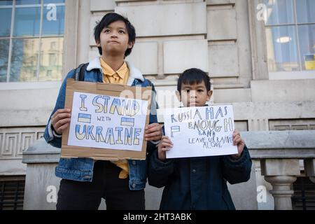 London, UK, 26th Feb 2022 A girls and her little brother hold up signs in Whitehall where housands have gathered to protest against Russia's recent attack on the Ukraine. Stock Photo