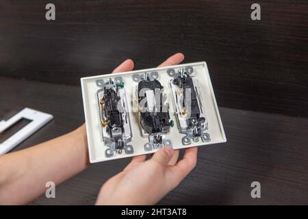 Checking the electrical outlet before installing it in a junction box on the wall Stock Photo