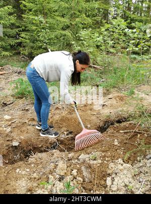 Woman raking in the garden Stock Photo