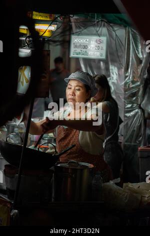 Female street Chef cooking food in Bangkok Stock Photo